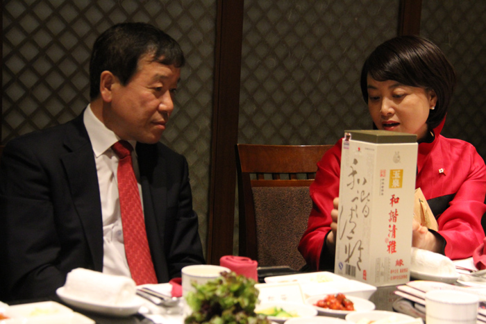  Director Kim Jae-won (left) of the Korean Culture and Information Service (KOCIS) speaks with Qu Huan, chairman of the Korea China Association for Cultural Exchange. Qu introduces to the KOCIS director a traditional alcohol that Korean independence fighter Ahn Jung-geun is known to have enjoyed. 