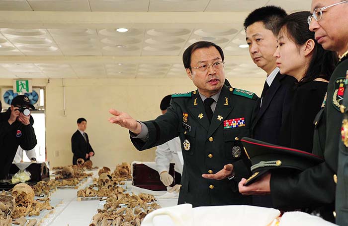 Korean Ministry of Defense official Yoo Cha-young (fourth from right), the head of the excavation team, explains the coffin ceremony procedure to Chinese Ministry of Civil Affairs official Li Guiguan (third from right) on March 17 at a cemetery where coffin rites for the Chinese soldiers were held. (photo courtesy of Ministry of National Defense)