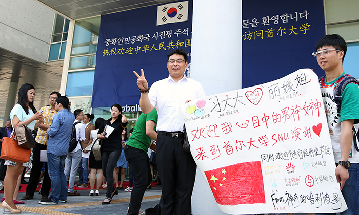  Chinese students with a placard welcoming President Xi Jinping pose for a picture in front of the Global Education Center for Engineers at Seoul National University on July 4. (photo: Jeon Han) 