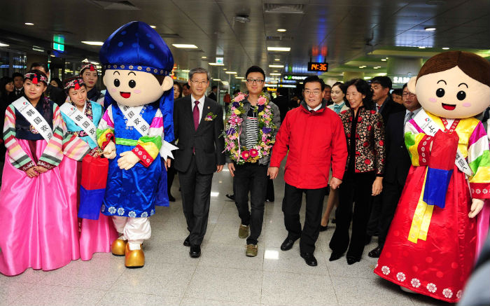 Vice Minister Cho Hyun-jae (fourth from left) of the Ministry of Culture, Sports and Tourism, Chinese traveler Ma Jiao (center) and Governor of the Jeju Special Self-Governing Province Woo Keun-min pose for photos during an event to welcome the arrival of the 12 millionth tourist to visit Korea in 2013 at Jeju International Airport on December 27. (Photo courtesy of the MCST)