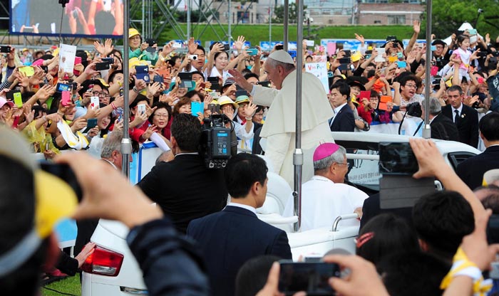 Pope Francis receives a rapturous welcome from the crowd as he enters the Haemi Fortress in a white open-topped car. 