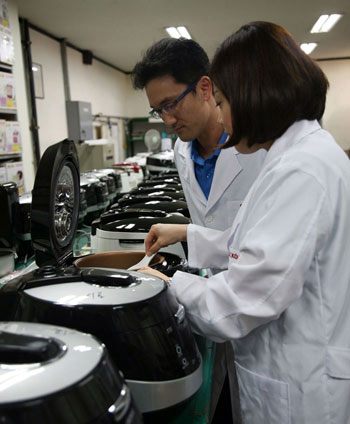 Researchers at Cuckoo Electronics examine the cooked rice from a Cuckoo rice cooker.