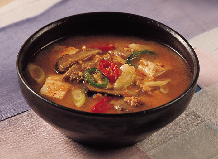 Soybean paste stew, or <i>Doenjang-jjigae</i>, is made with tofu, zucchini and other ingredients, seasoned with soybean paste. Made from fermented soybeans, this paste serves as a seasoning to add more flavor to the broth.