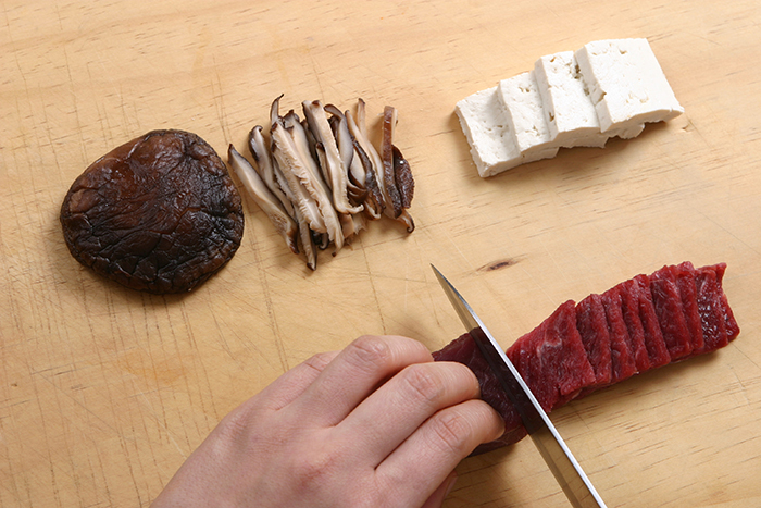 Cut the beef and tofu into bite-sized pieces. Wipe away any water from the soaked brown oak mushrooms and shred them into thin slices.