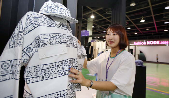 Designer Kim So-yeon of 2PLACEBO checks on her clothes on display at a pop-up booth at Fashion KODE 2014 on July 16. (photo: Jeon Han)