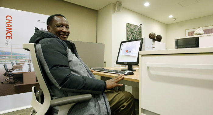 A staff member from the Central Bank of Kenya smiles as he tries out a chair on display in the Fursys showroom on December 18.