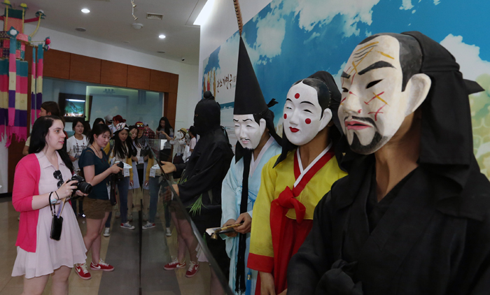 Visitors appreciate <i>tal</i>, masks used for traditional performances, part of the Gangneung Danoje festival, at the Gangneung Dano Culture Center in Gangneung, Gangwon-do, on June 1. (photo: Jeon Han)