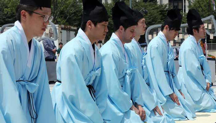Expatriates and members of multicultural families learn the ancestral ritual by taking part in a demonstration event while wearing the attire of Joseon-era Confucian scholars. (photo: Yonhap News)