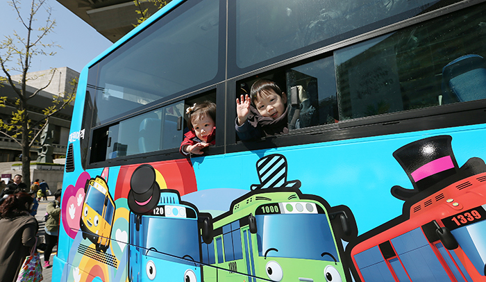 Children wave out the windows of Tayo on April 6 at Gwanghwamun Square in central Seoul. (photo: Jeon Han)