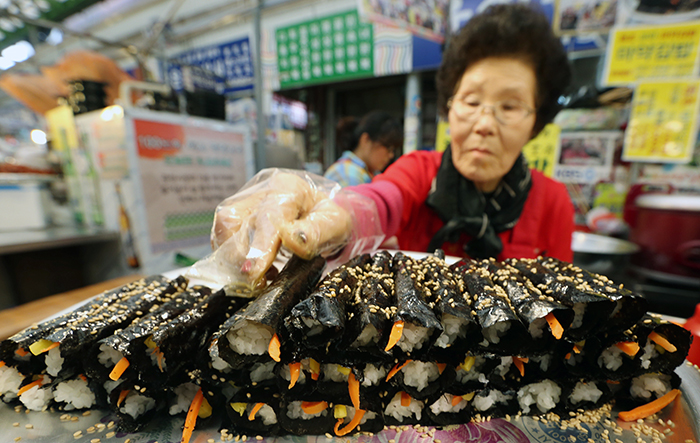 Dubbed “narcotic" <i>gimbap</i> for its addictive taste, <i>mayak gimbap</i> is known as one of the most iconic foods of Gwangjang Market. It is made with cooked rice, seaweed, vegetables, sesame oil and sesame seeds. (photo: Jeon Han)