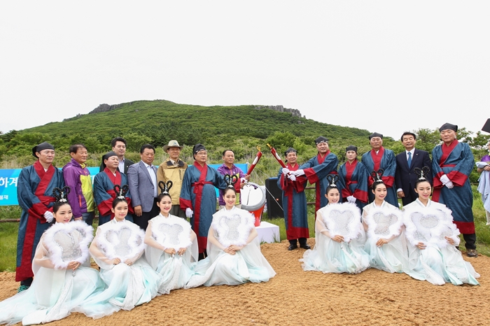 Co-joining flames lit both locally and internationally, participants pose for a photo after lighting the joint flame for the Gwangju Summer Universiade Games at the Jangbuljae mountain pass at Mudeungsan National Park.
