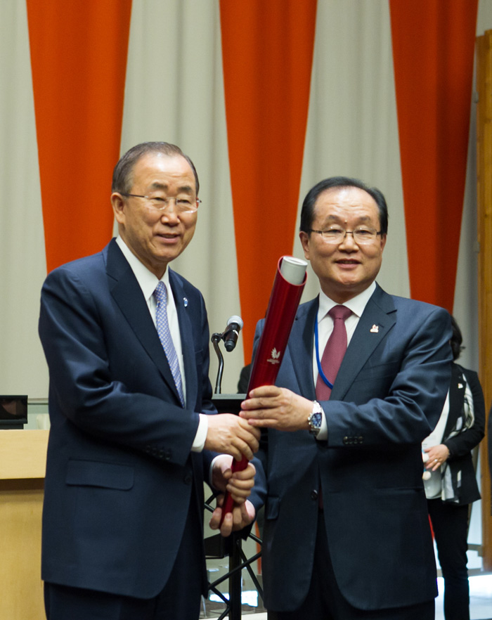 GUOC Secretary General Kim Yoon-suk (right) passes the official Universiade torch to UN Secretary General Ban Ki-moon during a ceremony to mark the second International Day of Sports for Development and Peace, at UN headquarters on April 15. 