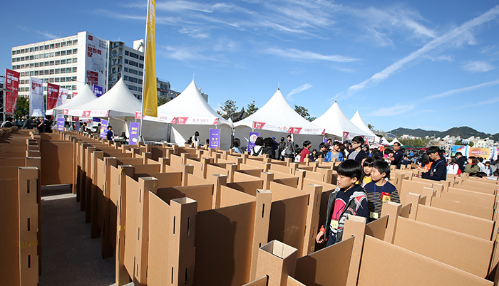 Fair-goers enjoy the Gwangjang Festival held at the Asian Culture Complex in Gwangju as they navigate a cardboard maze. 
