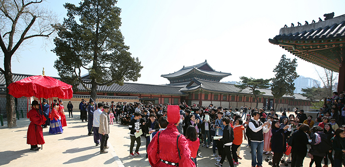 Visitors watch a reenactment of a ceremonial appointment of a royal gate keeper at Gyeongbokgung Palace in March 2016. More than 10 million people visited Seoul's four main royal palaces and Jongmyo Shrine this year.