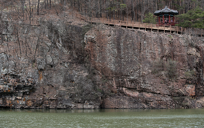 A pavilion is located next to a walking path on a cliff in Ipgok County Park in Haman County.