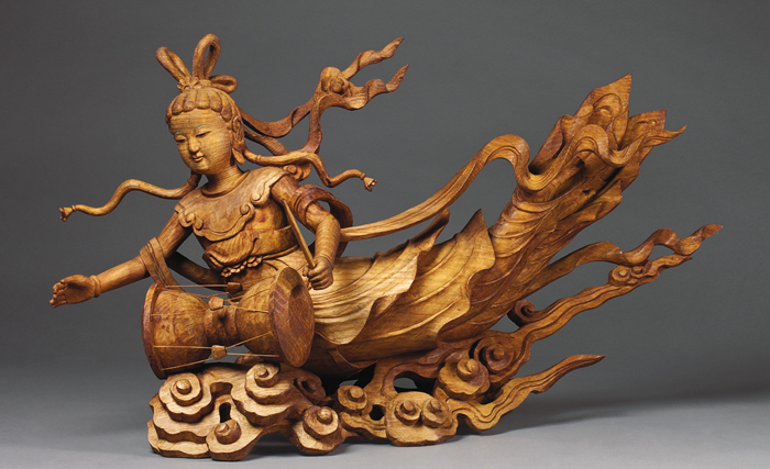 Artisan Heo Kil-yang’s “A <i>Bicheon</i> Playing a Lute with a Phoenix Head” (top) shows a <i>bicheon</i>, or celestial deva, slowly flying across the sky as she plays a lute. Another carving of his, “A <i>Bicheon</i> Playing a Drum” (bottom), is carved into the shape of a heavenly maiden with a heart-warming smile playing a drum. (Photos courtesy of Heo Kil-yang)