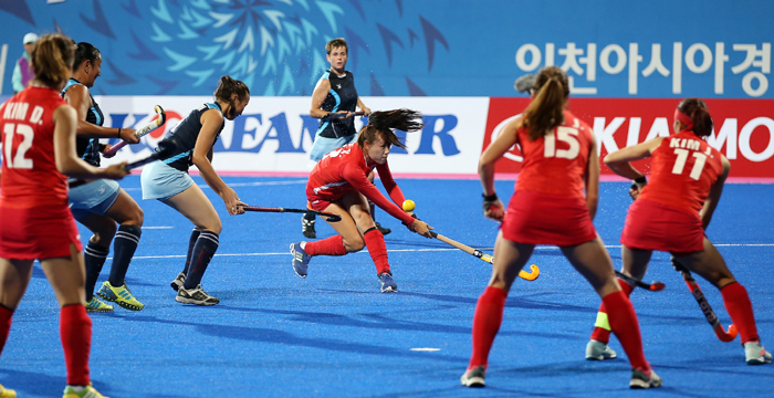 Hockey players from Korea, in red, and Kazakhstan, in blue and black, face off in the women’s hockey Pool B match held at the Seonhak Hockey Stadium in Incheon on September 22. 