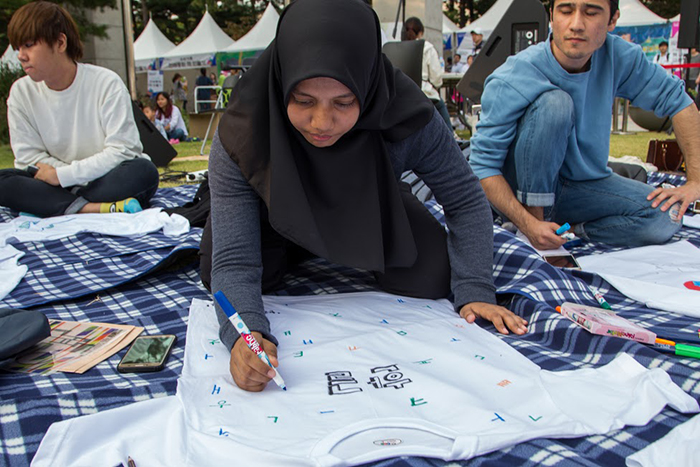 Malaysian competitor Zahra ahan writes Korean consonants and vowels on a T-shirt, as part of a Hangeul T-shirt design competition at the National Hangeul Museum on Oct. 8, one day before the 571st anniversary of the creation of the Korean alphabet.