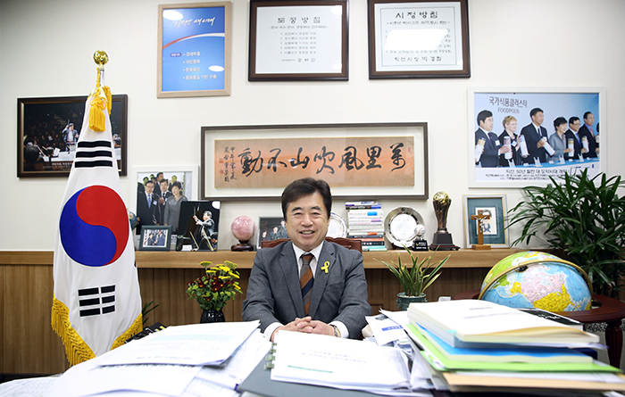 Mayor Park leads a busy work life at a desk stacked with papers and documents. He emphasizes the need to make endless development and reform.