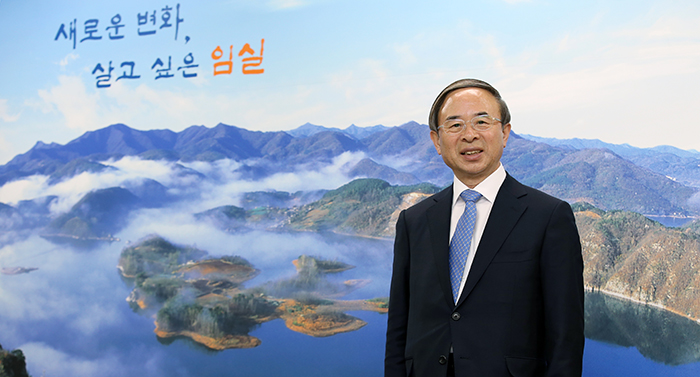 One wall in Mayor Sim Min's office is covered with an oversized photograph of Bungeoseom Island in Okjeongho Lake. Mayor Sim says that the island and the surrounding lake, covered in heavy fog, is a matter of pride for the county and that photographers can create different pictures depending on the time, season and location.