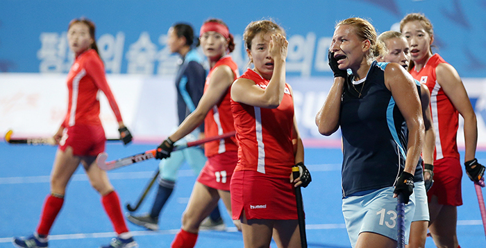 Korea’s Kim Darae (second from right) and Alissa Chepkassova (right) from Kazakhstan cover their faces after being injured by the ball during a preliminary match in women’s hockey on September 22. The Kazakhstani athlete could have faced bigger injuries, but she endured the pain and continued on the field.