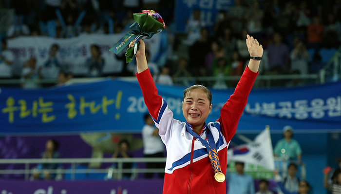 Kim Unhyang of North Korea raises her arms while shedding tears after winning the gold medal in the women’s beam final on September 25. Kim said, "The blood and sweat in training is the weight of the gold medal,” hinting that she had been training hard.
