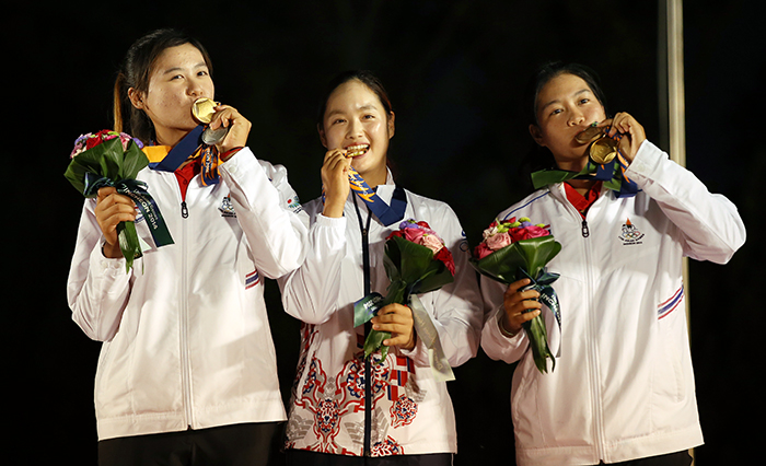  Park Gyeol of Korea (middle), Sukapan Budsabakorn (left) and Sangchan Supamas (right), both from Thailand, bite into their medals during the awards ceremony in the women's individual golf competition at the Asian Games in Incheon on September 28. 