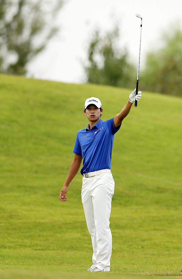  Kim Nam-hun of Korea holds up his iron to the cheering gallery after landing his ball close to the flag on the 16th hole, during the fourth round of the golf competition at the Asian Games in Incheon on September 28. 