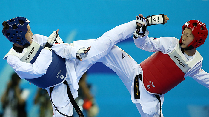 Huang Yun Wen of Chinese Taipei (left) and Korea’s Yoon Jeongyeon launch simultaneous kicks during the women’s 53 kilogram event on September 30 in the Incheon Asian Games 2014.