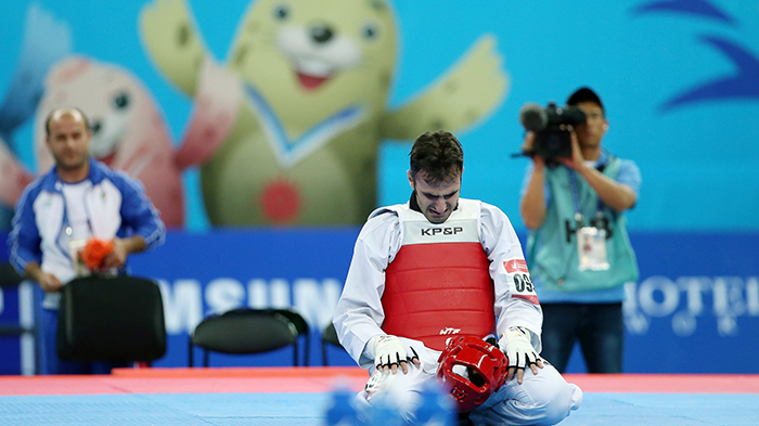 Hajizavareh Masoud from Iran kneels after securing gold in the men’s taekwondo 74 kilogram event on September 30 during the Incheon Asian Games.