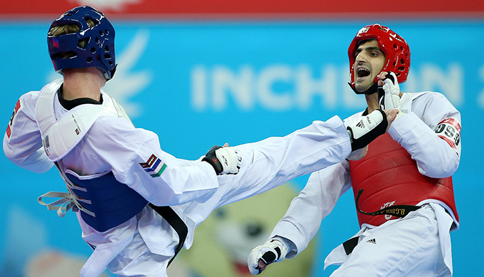 Hajizavareh Masoud (right) of Iran blocks a kick from Rafalovich Nikita of Uzbekistan during the gold medal match in the men’s taekwondo 74 kilogram event on September 30 at the Incheon Asian Games 2014.