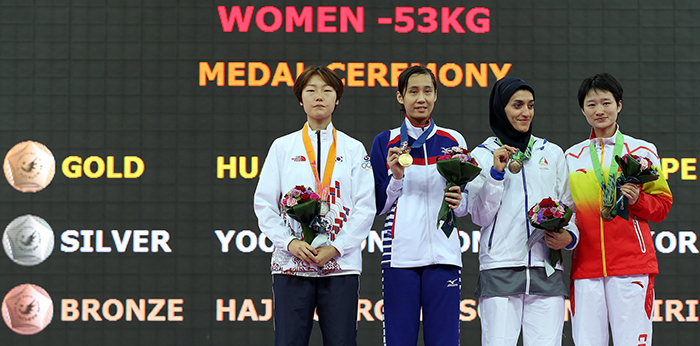 Medalists in the women’s taekwondo 53 kilogram event smile on the podium after the award ceremony on September 30 during the Incheon Asian Games 2014.