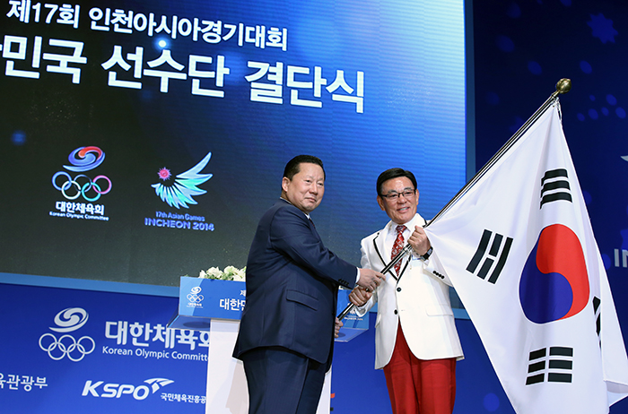 In preparation for the Incheon Asian Games 2014, the leader of the Korean athletes’ delegation, Park Soon-ho (right), receives the Taegeukgi from Korean Olympic Committee President Kim Jung-haeng during Team Korea's launch ceremony on September 11.