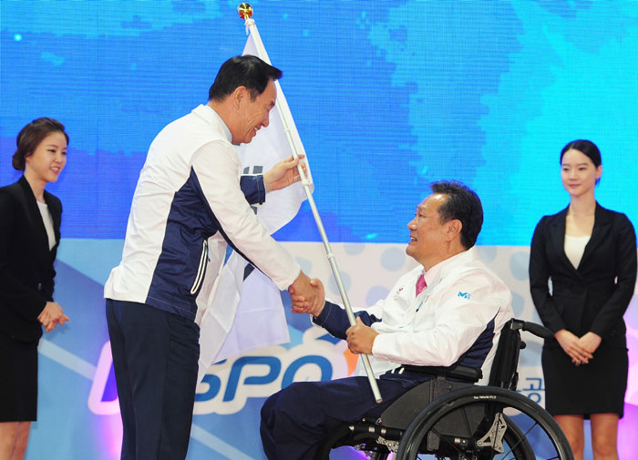 Kim Rak-hwan (second from right), head of the national team for the Incheon Asian Para Games 2014, receives the Taegeukgi, the Korean national flag, from Kim Sung-il, president of the Korea Paralympic Committee, during the Team Korea launch ceremony for the Incheon Asian Para Games 2014.