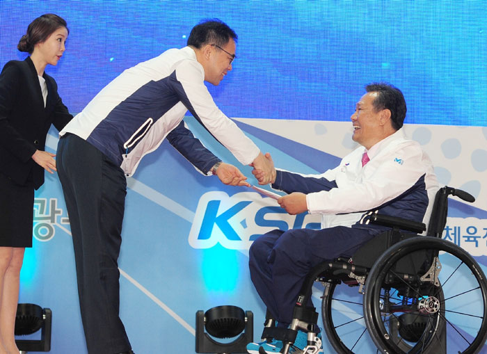 Second Vice Minister of Culture, Sports & Tourism Kim Chong (center) offers some incentive money to Kim Rak-hwan (right), the head of the national team for the Incheon Asian Para Games 2014, during the Team Korea launch ceremony.