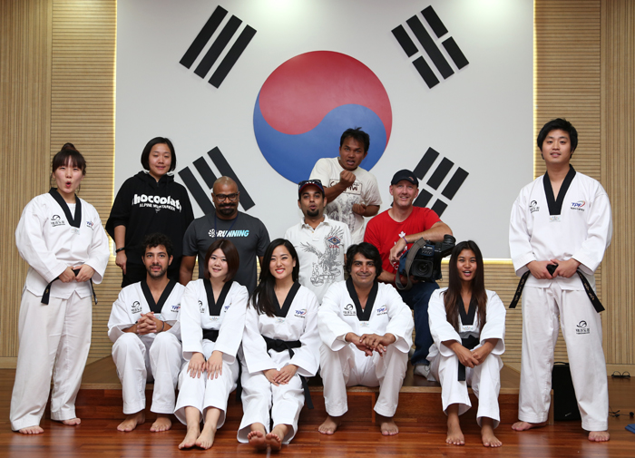 Journalists don the official uniform and practice the traditional martial art taekwondo. 