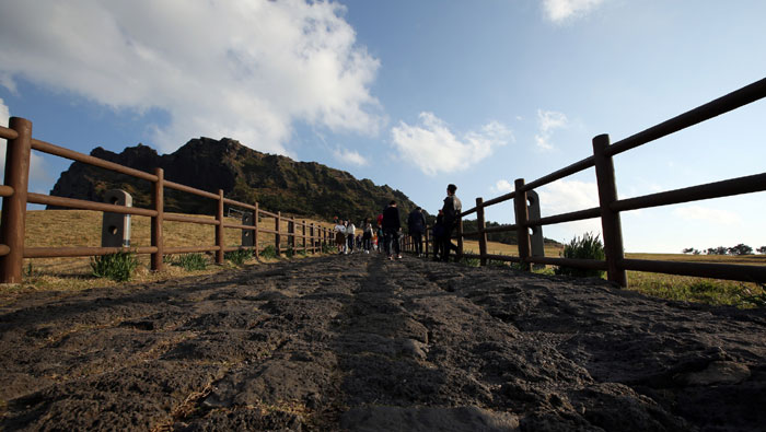 The bottom of the entrance to the Seongsan <i>Ilchulbong</i> is covered with basalt. Basalt can be easily found on Jeju Island, reminding visitors that the island was created through volcanic activity.