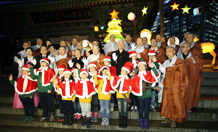 Buddhist monks and a children’s choir pose for a photo during a lighting ceremony for a Christmas tree at Jogyesa Temple in Jongro-gu, Seoul, on December 17. 