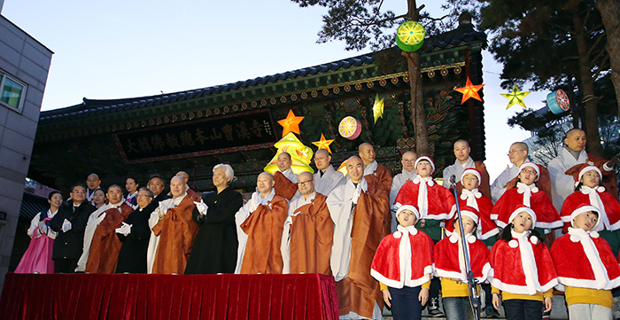 Representatives from different religions and a children’s choir sing Christmas carols during the lighting ceremony for a Christmas tree at Jogyesa Temple in Seoul on December 17. 