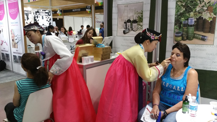 Visitors to KCON 2015 try some beauty products made by small- and medium-sized enterprises. 