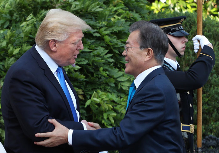 President Moon Jae-in (right) on June 29 is greeted by U.S. President Donald Trump at the South Portico of the White House in Washington.