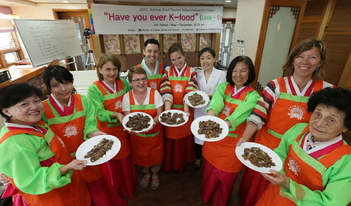 During a hands-on cooking class held on May 24, the foreign participants smile, holding a plate of neobiani they cooked (photo: Jeon Han)
