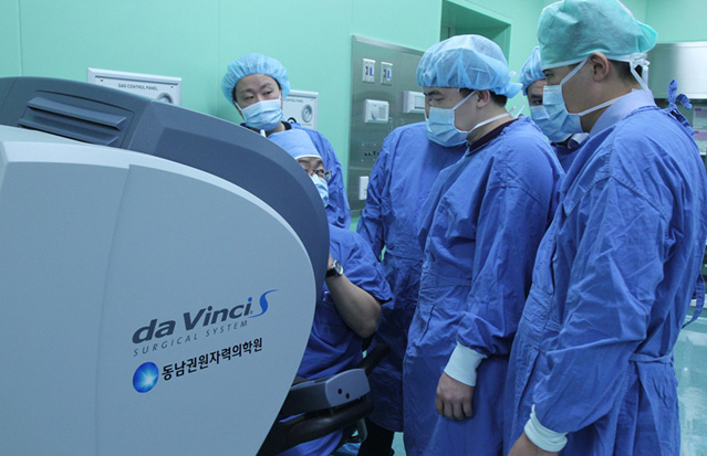 Visitors from Kazakhstan closely watch a surgery robot operating at Dongnam Institute of Radiological and Medical Sciences (photo: Yonhap News). 