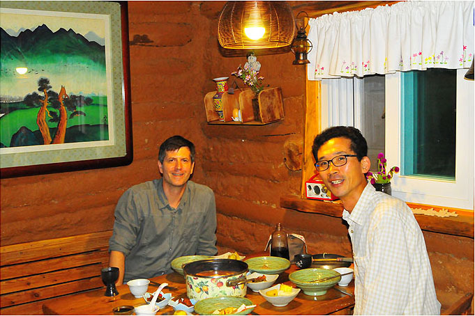 Farm owner Kim Young-mee excels at cooking and photography. Here WWOOFer David Kendall enjoys gejjigae (crab stew) and omija wine with her husband Im So-hyeon in their kitchen. 
