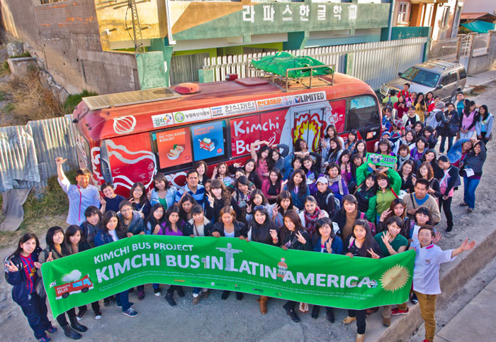 Fans of Korean cuisine gather by the red Kimchi Bus for a group photo. (photo courtesy of the Ministry of Agriculture, Food and Rural Affairs)