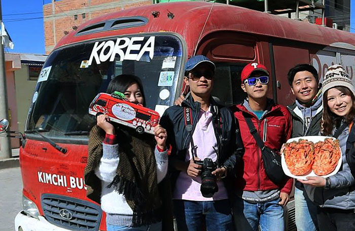 The Kimchi Bus team introduces kimchi to locals they meet in Uyuni, Bolivia, while travelling on the red bus. (photo courtesy of the official Facebook page for the Kimchi Bus Project)
