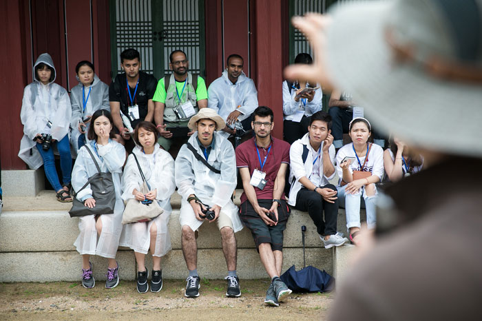 International students participating in a historical tour listen to an explanation about Namhansanseong Fortress.