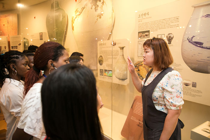 Participants listen to an explanation about celadon ceramic porcelain, <i>buncheongsagi</i> (분청사기) and <i>baekja</i> (백자), from a guide at the Gyeonggi Ceramic Museum.