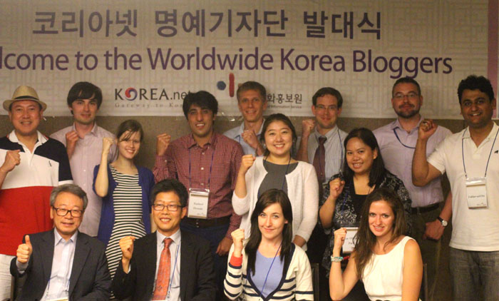 Members of the newest batch of WKB bloggers show their enthusiasm with clenched fists during a welcome ceremony on June 20. (photo: Wi Tack-whan)