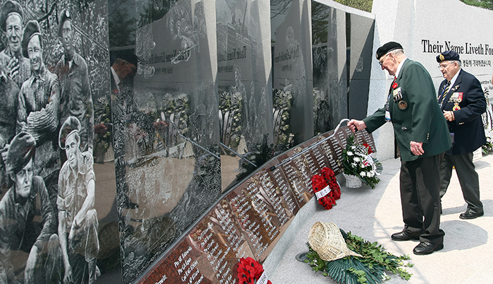 A member of a Korean War veterans' group points to the name of his colleague engraved in the commemorative wall on April 23. (photo courtesy of the Ministry of Patriots' and Veterans' Affairs)